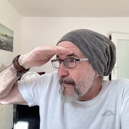Frank Hennemann mit Mütze und der Hand über den Augen nach vorn blickend